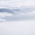 Montagne innevate coperte di nuvole basse — Foto stock