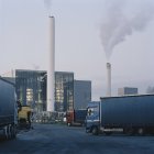 Edificios industriales con tuberías y camiones en primer plano - foto de stock