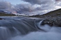 Malerischer Blick auf den fließenden Wasserfall und die Bergkette — Stockfoto