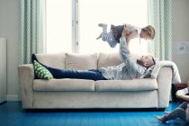 Father playing with daughters in living room — Stock Photo