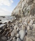 Stones on rocky coastline with surf waves — Stock Photo