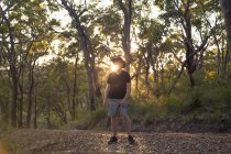 Senior turista nella foresta al tramonto, brillamento lente — Foto stock