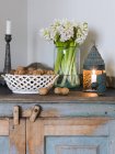 Hyacinths, candles and walnuts on wooden cabinet — Stock Photo