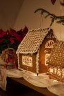 Illuminated gingerbread house and christmas decorations — Stock Photo