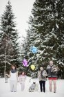 Família com duas crianças na floresta de inverno durante o Natal — Fotografia de Stock