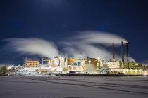 Long exposure shot of smoke over paper mill at night — Stock Photo