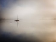 Front view of silhouette of sailboat in fog — Stock Photo