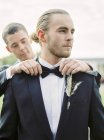 Noivo ajustando parceiro laço gravata no casamento gay — Fotografia de Stock