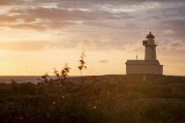 Lighthouse against cloudy sunset sky — Stock Photo