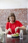 Улыбающаяся женщина обедает, дифференцированный фокус — стоковое фото