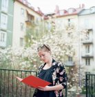 Donna con cartella rossa nel cortile residenziale — Foto stock