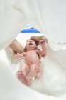 Woman bathing newborn baby girl, selective focus — Stock Photo