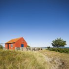 Scenic seascape with red cottage and blue sky — Stock Photo
