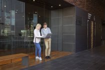 Colleagues using laptop in lobby, selective focus — Stock Photo