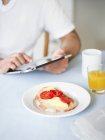 Середина людини, що використовує планшетний ПК за столом для сніданку — стокове фото