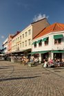 Vista de edificios y personas en restaurantes callejeros en Lilla Torg - foto de stock