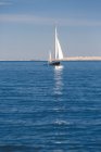 Vista panorámica del hombre viajando en velero en el mar - foto de stock