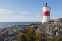 Мальовничий вид на узбережжя з маленьким маяком на сонячному світлі — стокове фото