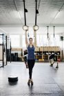Молодая женщина тренируется на гимнастических кольцах — стоковое фото
