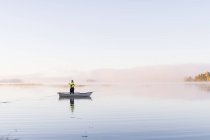 Giovane pesca nel lago al tramonto — Foto stock