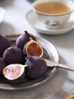 Figos inteiros e meio frescos e xícara de chá — Fotografia de Stock