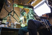 Low angle view of young man welding metal — Stock Photo
