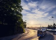 Bus fährt auf sonnenbeschienener Straße, Stockholm — Stockfoto