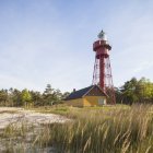 View of lighthouse and building at edge of forest — Stock Photo