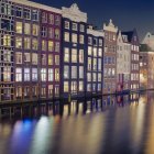 Edificios residenciales en el canal de agua borrosa, Amsterdam - foto de stock