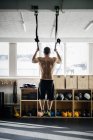Молодий чоловік тренується на гімнастичних кільцях — стокове фото