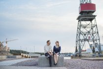 Paar sitzt auf Block und redet auf Baustelle — Stockfoto