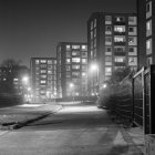 Edificios del distrito residencial iluminados por la noche, en blanco y negro - foto de stock