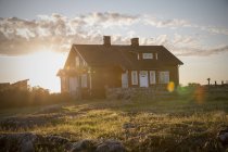 Casa de madeira sueca tradicional no por do sol retroiluminado — Fotografia de Stock
