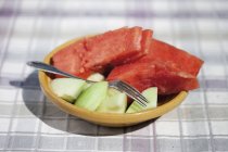 Sandía y melón mitades en plato con tenedor - foto de stock