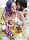Наречена цілує наречену на хіпі весілля, фокус на передньому плані — стокове фото