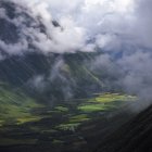 Valle de montaña verde con nubes bajas - foto de stock