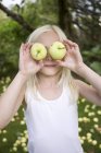 Ragazza con mele nel frutteto, focus selettivo — Foto stock