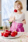 Girl holding candied apple, differential focus — Stock Photo