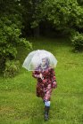 Frau trägt gefleckten Regenmantel auf Feld — Stockfoto