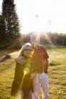 Homem e mulher juntos no prado à luz do sol — Fotografia de Stock