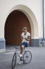 Чоловік сидить на велосипеді і використовує мобільний телефон — стокове фото