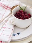 Fresh lingonberries in white cup on plates — Stock Photo