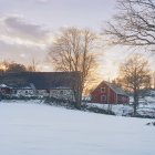 Casas no monte snowcapped com céu nublado do por do sol — Fotografia de Stock