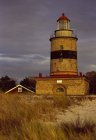 Bâtiment phare avec herbe haute au premier plan — Photo de stock
