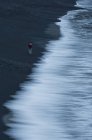 Vista elevada de la mujer caminando a lo largo del surf - foto de stock