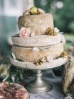 Italian cheese heads on cake stand decorated with flowers — Stock Photo