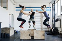 Молодые женщины и мужчины прыгают в спортзале — стоковое фото