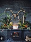 Glamor antlers hanging over luxurious fireplace — Stock Photo