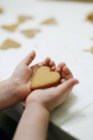 Heart shaped cookie in little girl hands — Stock Photo