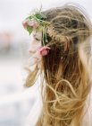 Profile of young woman with flowers in hair — Stock Photo